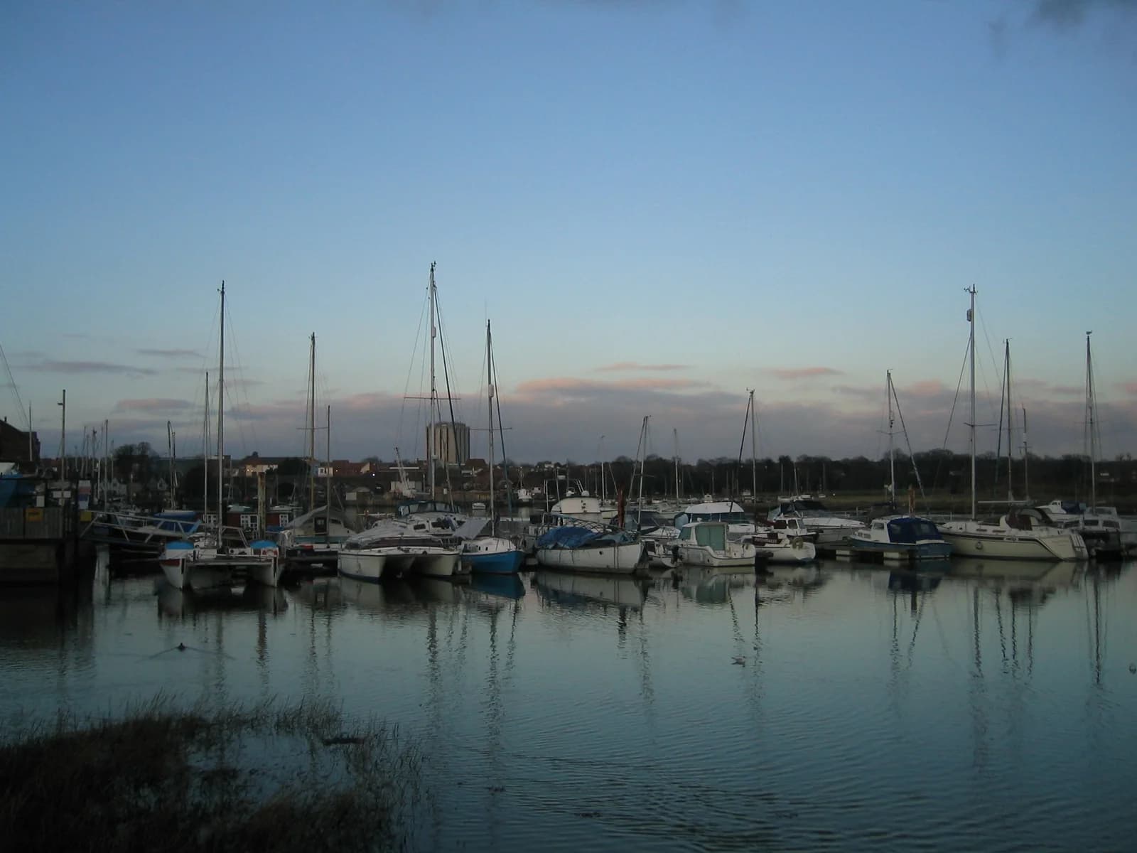 Boats reflected in the still water of Fareham Creek at dusk